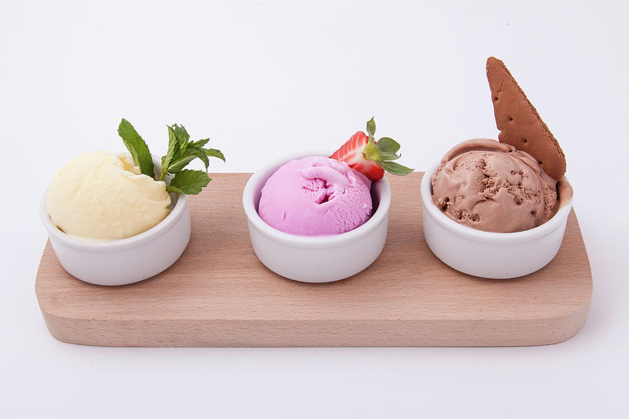 Three Cups Of Different Flavors Of Ice Cream On Wooden Board. Chocolate, Vanilla And Strawberry Photograph