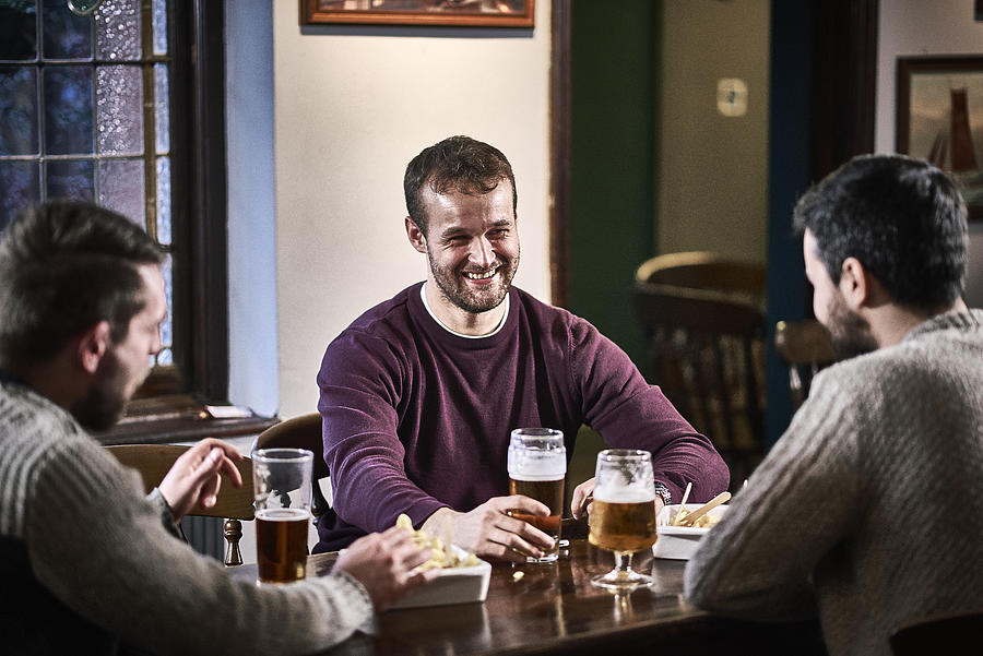 Three friends sat in a traditional British pub enjoying each others company Photograph by Jamie Garbutt