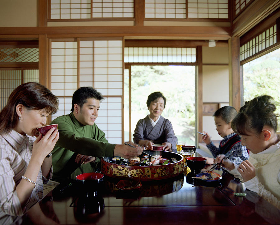 Three generation family eating sushi Photograph by Ryan McVay