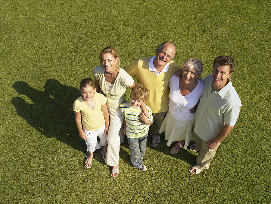 Three generational family on lawn, smiling, portrait, overhead view Photograph by Flying Colours