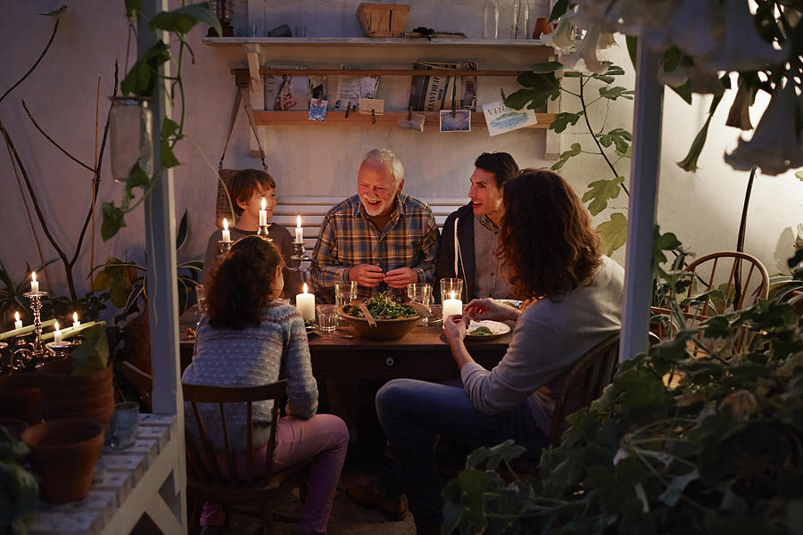 Three generations having cozy meal in garden house Photograph by Klaus Vedfelt