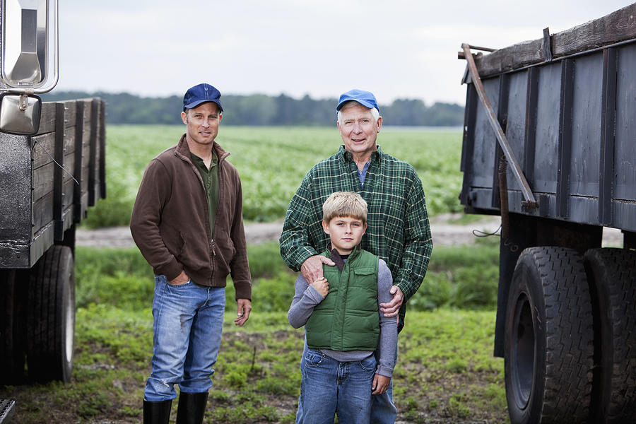 Three generations of men on family farm Photograph by Kali9