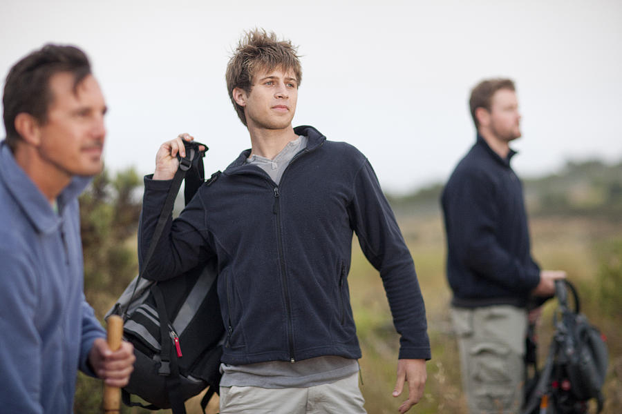 Three men hiking in rural landscape Photograph by Zero Creatives