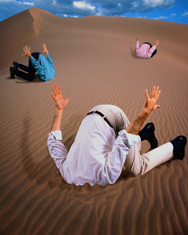 Three men with heads buried in sand dune (Digital Composite) Photograph by John Lund
