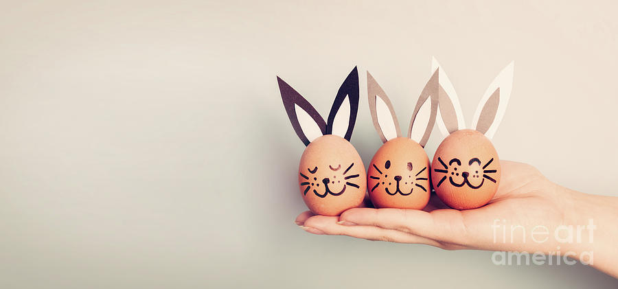 Three painted smiling Easter eggs bunnies on womans hand Photograph by Michal Bednarek
