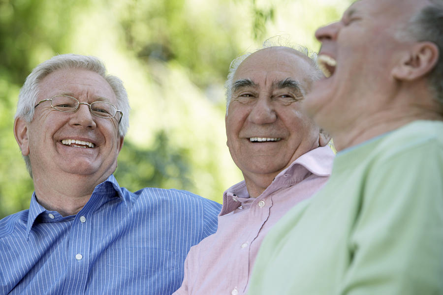 Three senior men laughing, close-up (focus on man wearing glasses) Photograph by Liz Gregg