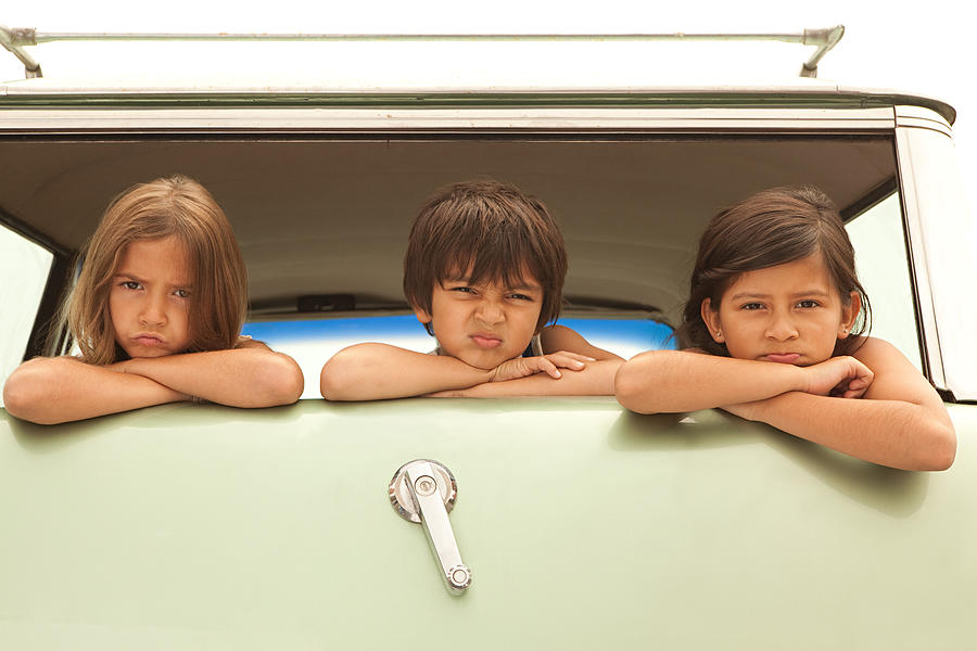 Three sullen children in back of estate car Photograph by Image Source