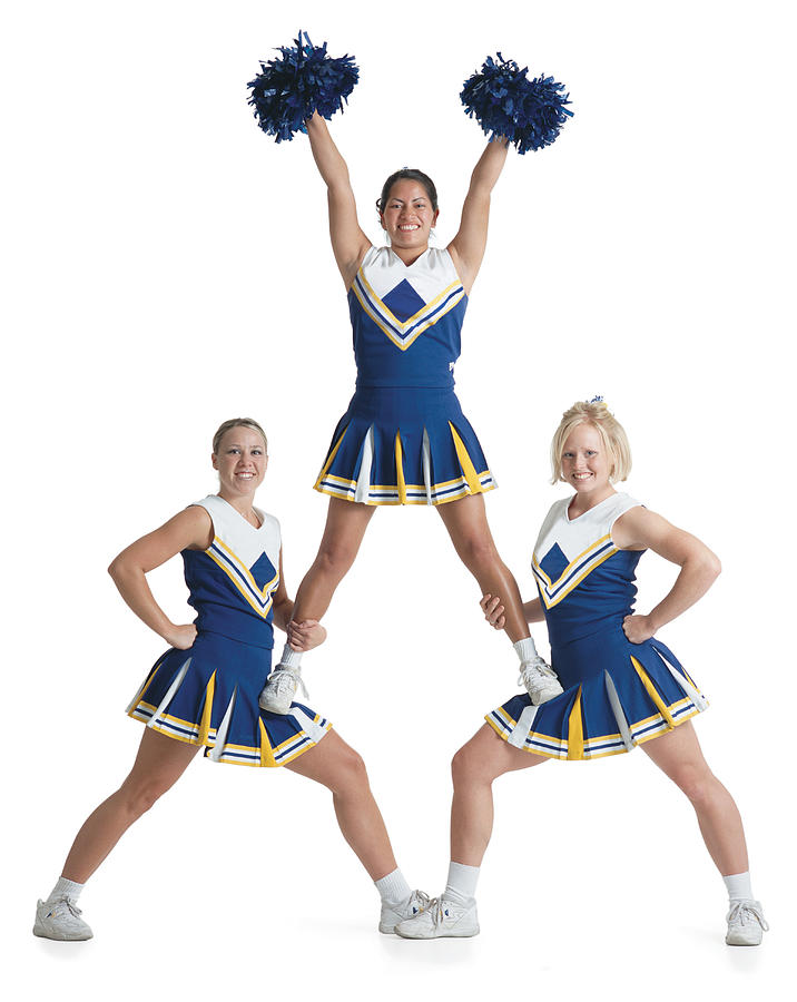 Three Teenage Caucasian Female Cheerleaders In Blue Uniforms Cheer As They Form A Small Pyramid Photograph by Photodisc