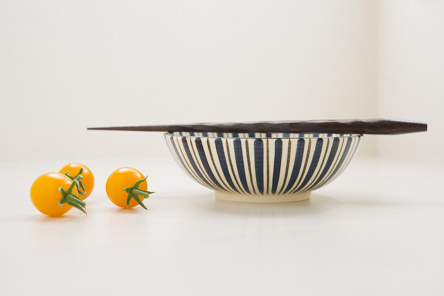 Three yellow tomatoes and a bowl with chopsticks Photograph by Margarita Komine
