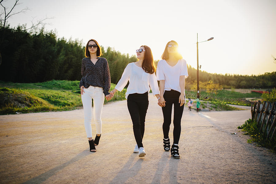 Three young women walking in park Photograph by Insung Jeon