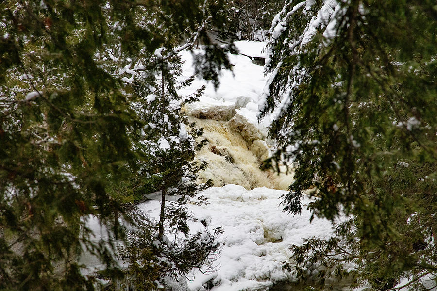 Through the trees view of Canyon Falls in the winter in Michigan Photograph by Eldon McGraw