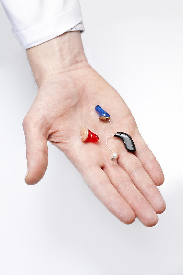 Tiny hearing aids on doctors hand Photograph by Maica