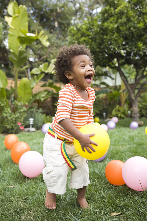 Toddler boy (21-24 months) playing with balloons in yard Photograph by Reggie Casagrande