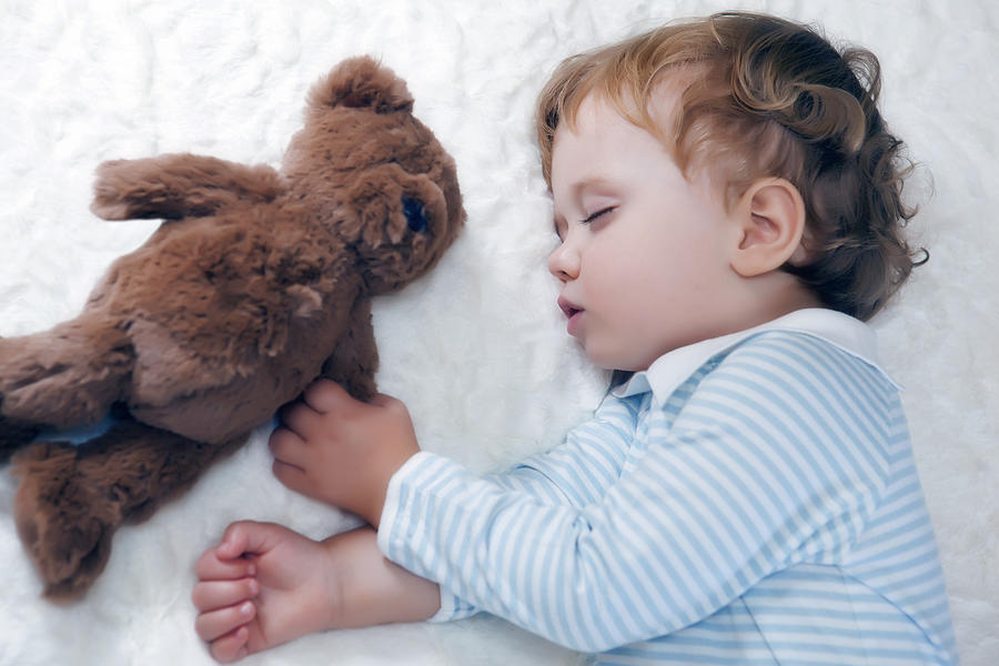 Toddler boy asleep holding a teddy bear Photograph by Caroline Purser