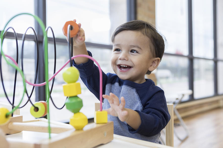 Toddler boy enjoys playing with toys in waiting room Photograph by SDI Productions