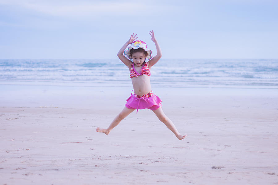Toddler girl jumping on the beach Photograph by Suphat Bhandharangsri Photography