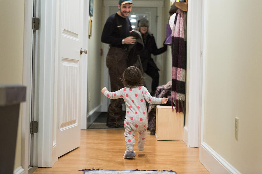 Toddler running towards parents whove just returned home Photograph by Catherine Ledner