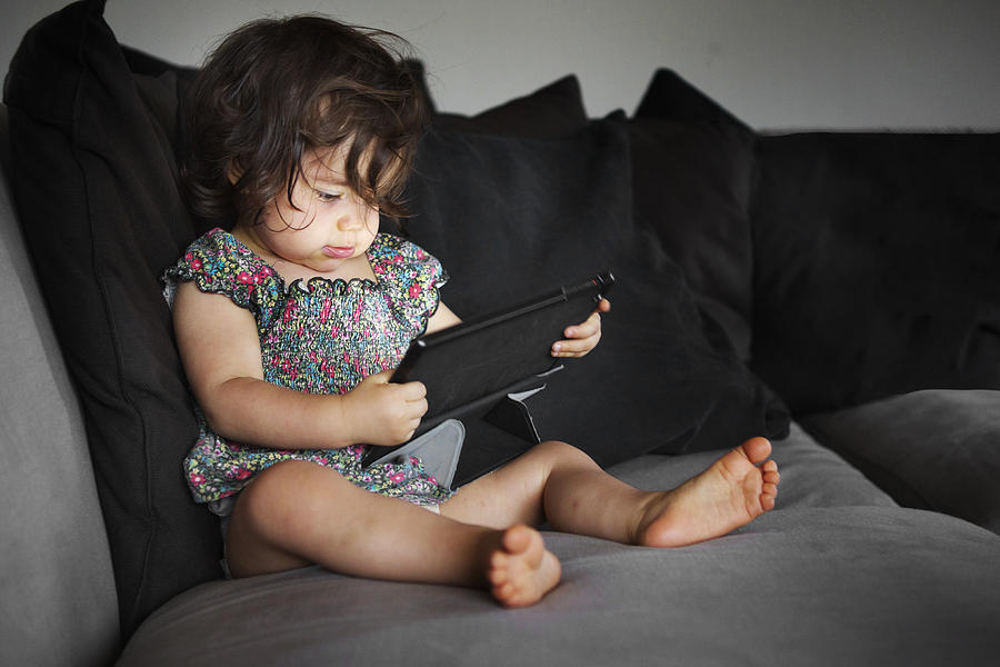 Toddler with a tablet in the sofa Photograph by Am2photo