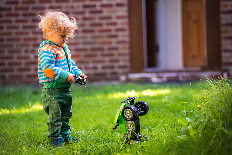 Toddler with toy car Photograph by © Razvan Ciuca