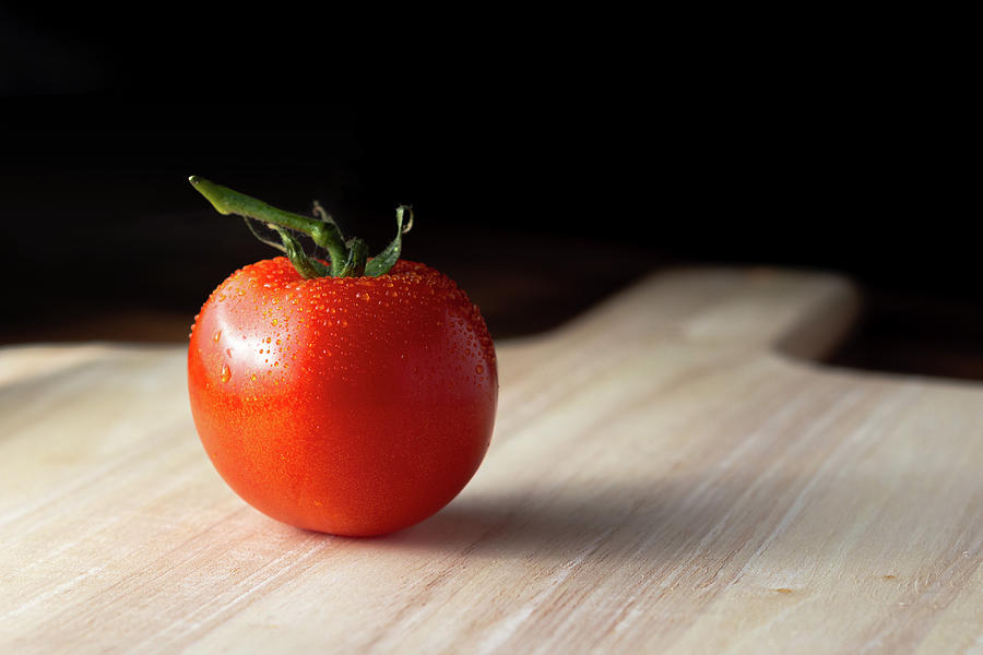 Tomato on a wooden board Photograph by Scott Lyons