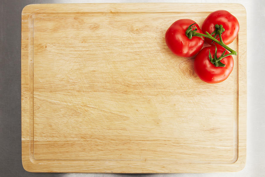 Tomatoes on a chopping board Photograph by Stocknroll