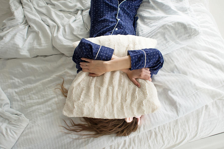 Too lazy to get out of bed, a woman covers her face with a pillow Photograph by KrisCole