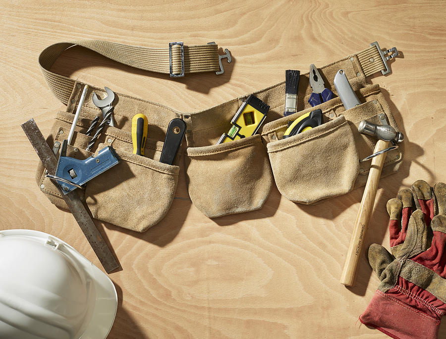 Toolbelt on a wooden background Photograph by David Rowland