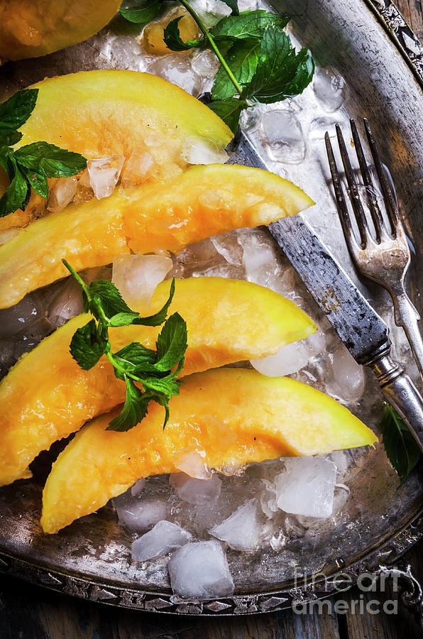 Top View Of Cantaloupe Melon Slices With Mint And Ice Served  On Photograph