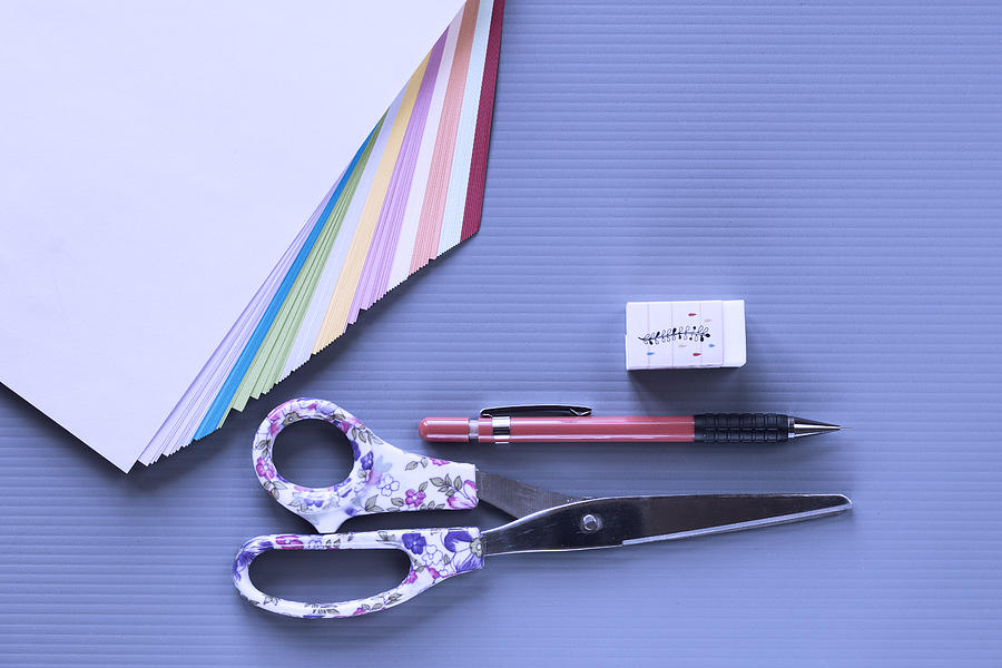 Top view of group of school or office supplies on blue background. Copy space for text and/or logo Photograph by Rosa María Fernández Rz