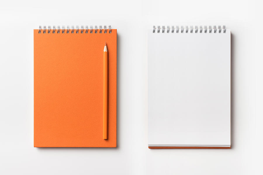 Top view of orange spiral notebook and color pencil collection Photograph by Voyata