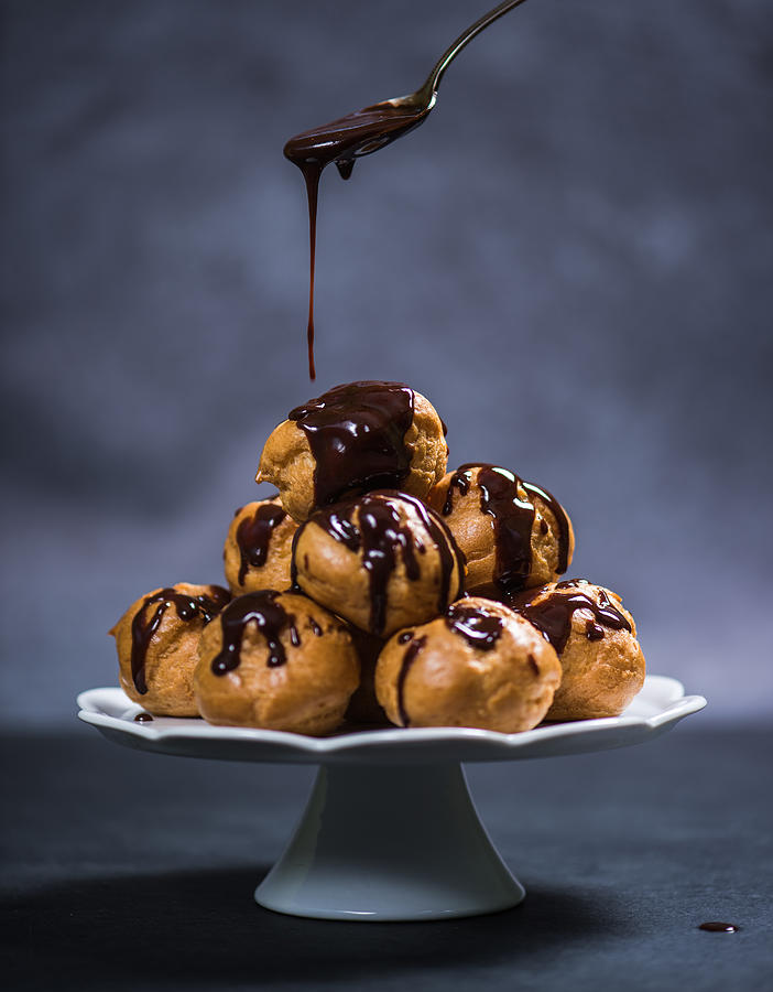 Topping profiterole tower with chocolate Photograph by Merc67