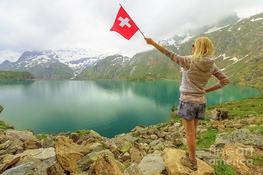 Tourist at Robiei lake with swiss flag Photograph by Benny Marty
