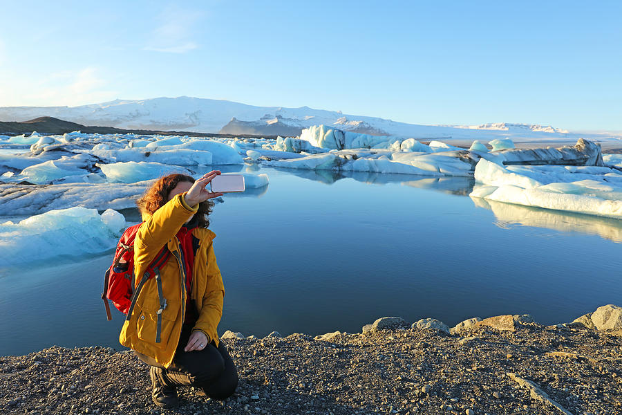 Tourist Hiker Taking Selfie at Jokulsarlon Glacial Lagoon in Iceland Photograph by JurgaR