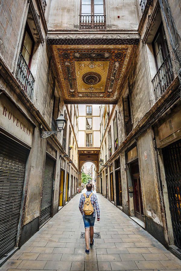 Tourist with backpack bag wandering through the narrow street of Gothic Quarter in Barcelona, Catalonia, Spain Photograph by Alexander Spatari