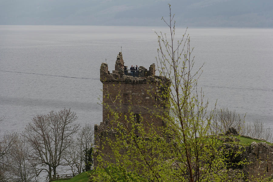 Tourists at the top of the remains of a tower in the Urquhart Ca Photograph by Ashish Agarwal