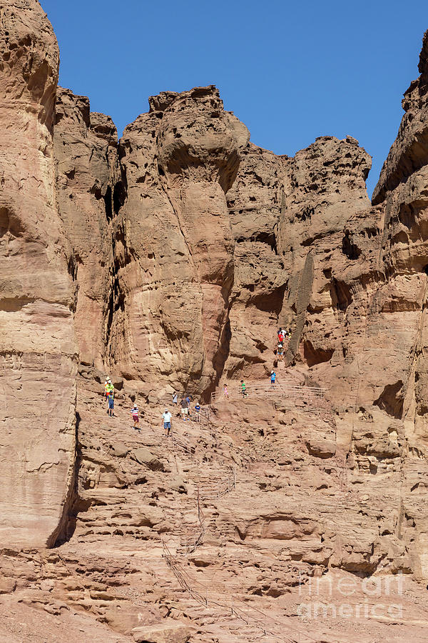 Tourists hike a trail near Solomons Pillars in Timna Valley in  Photograph by William Kuta
