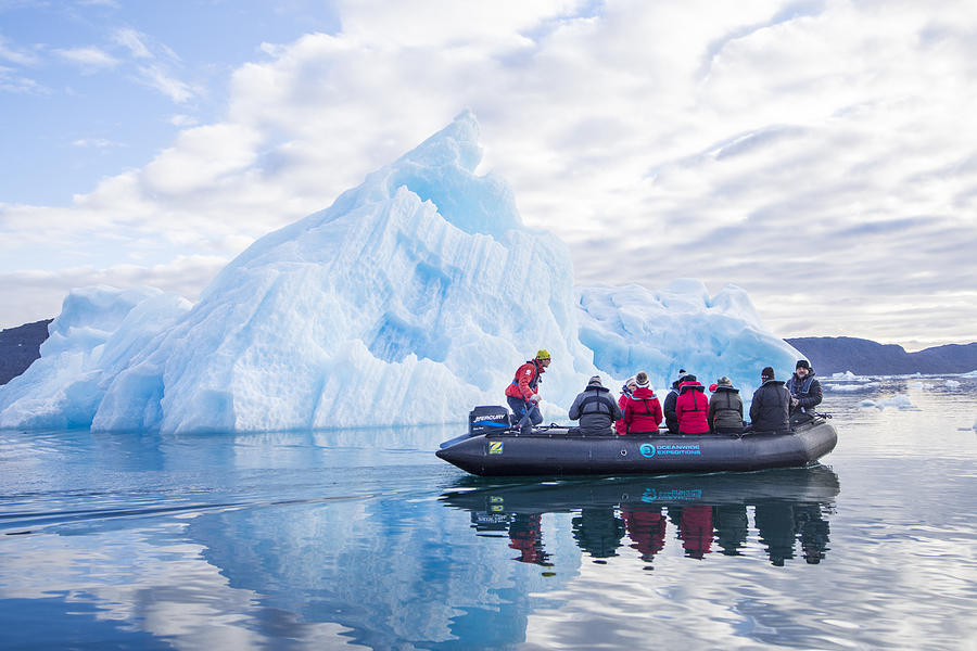 Tourists in a Zodiac in front of an iceberg, Greenland Photograph by Guenterguni