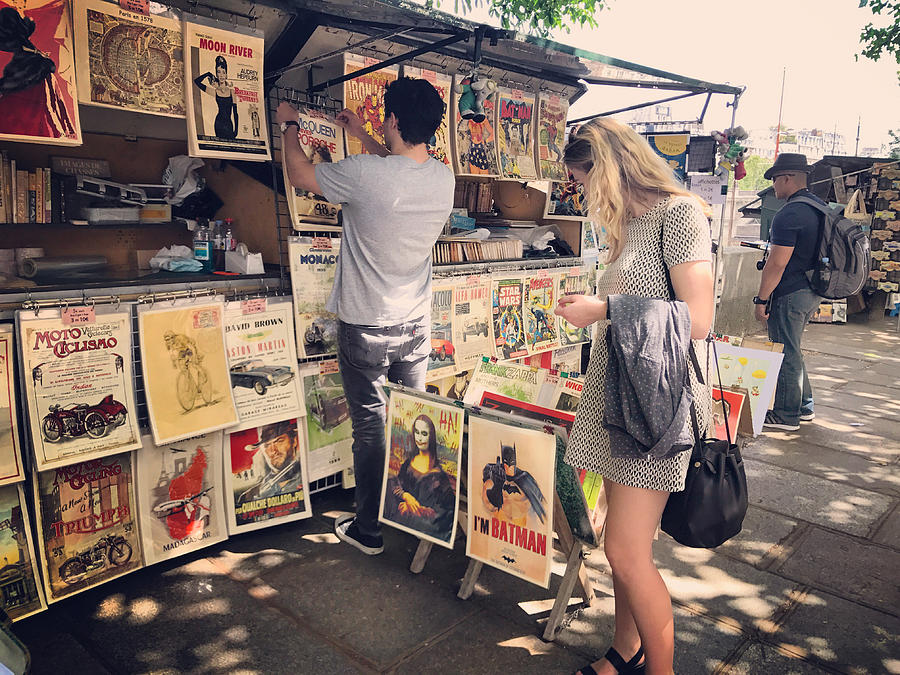 Tourists looking at vintage posters for sale on Paris embankment, France Photograph by Anouchka