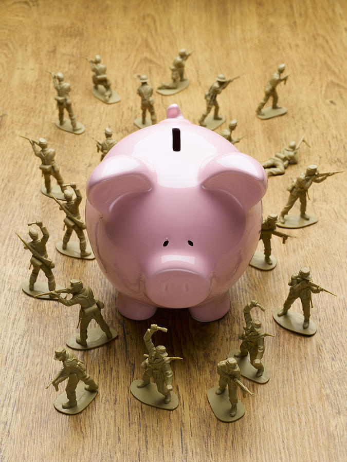 Toy army men surrounding piggy bank Photograph by Andy Roberts