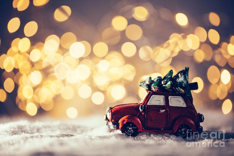 Toy car with Christmas tree driving in snow. Photograph by Michal Bednarek
