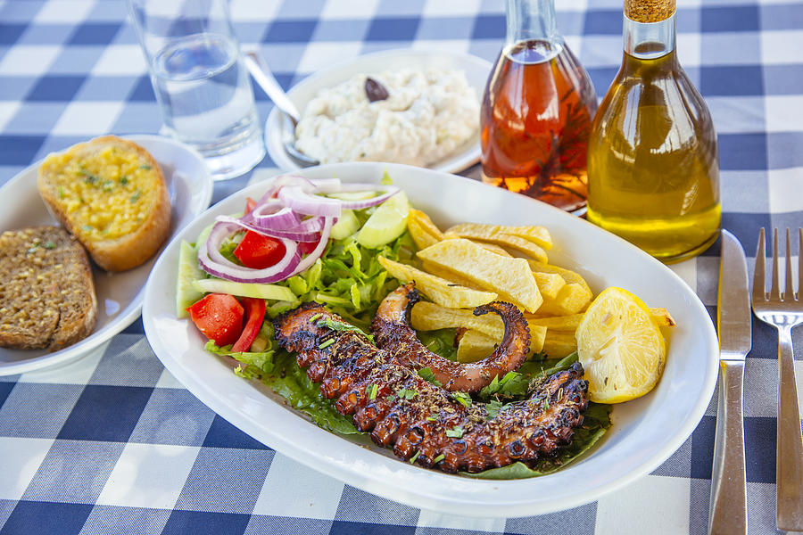 Traditional Greek dinner with grilled octopus and tzatziki Photograph by Alexander Spatari