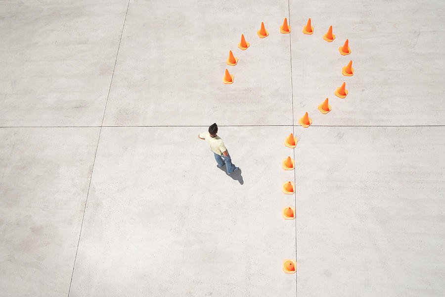Traffic cones forming question mark with man inside Photograph by Martin Barraud