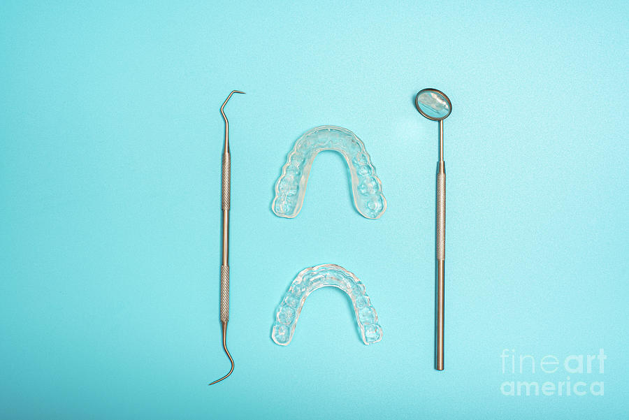 Transparent dental aligner next to dentist mirror, copy space. Photograph by Joaquin Corbalan