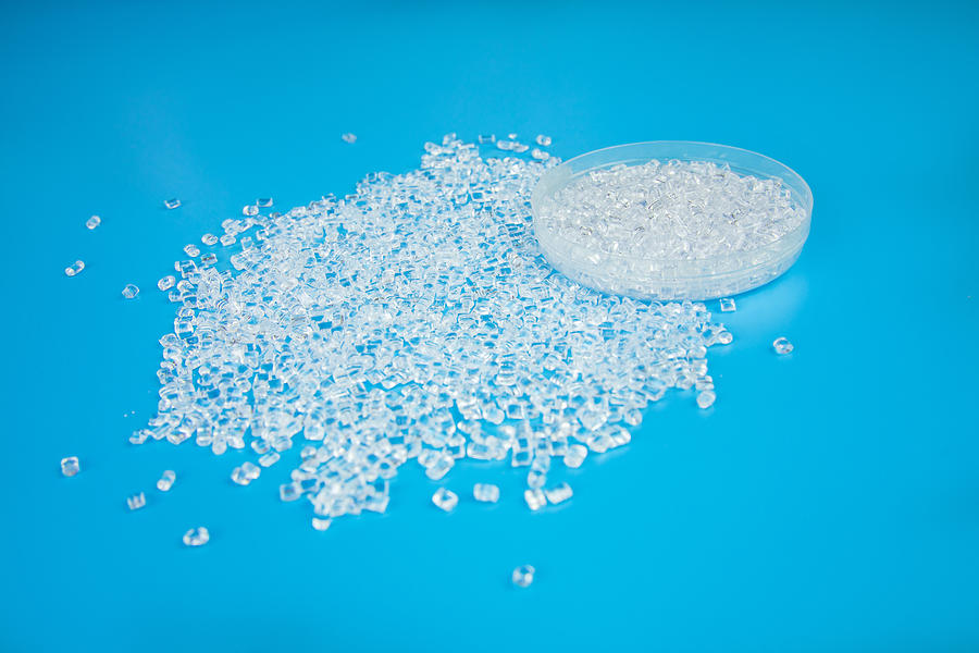 Transparent Polypropylene, polypropene, polystyrene, polyethylene, thermoplastic polymer, HDPE and plastic raw material pellets or granules on isolated blue background Photograph by Yagmradam
