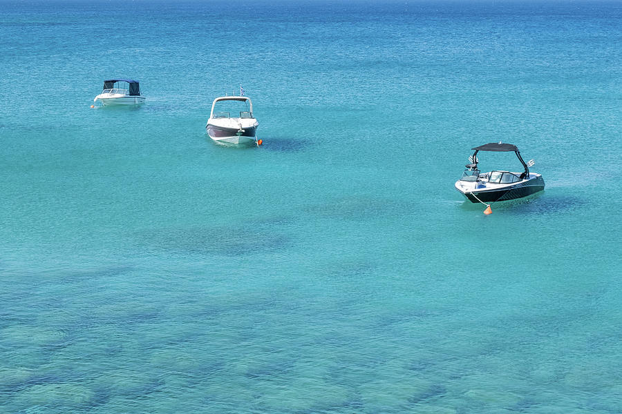 Travel boats resting on the calm sea with turquoise water. Photograph by Michalakis Ppalis