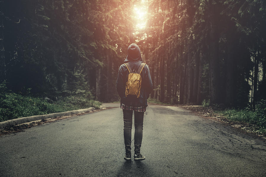 Traveler with backpack walking in a foggy forest at sunset Photograph by Da-kuk