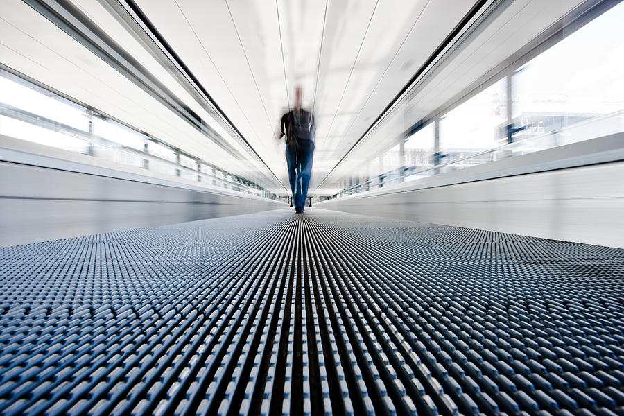Traveller walking on moving stairway airport walkway Photograph by Mlenny