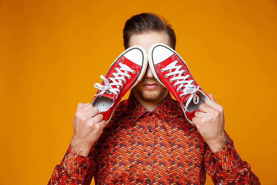 Trendy man covering eyes with red sneakers Photograph by Iuliia Isaieva