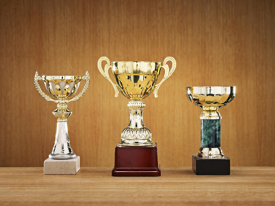 Trophies on wooden background Photograph by Johner Images