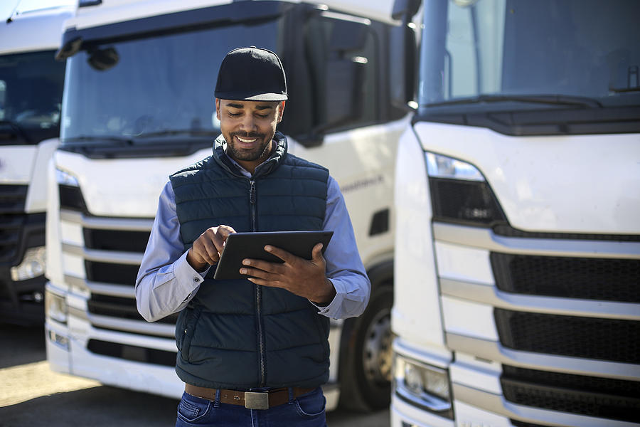Truck driver using a tablet Photograph by GoodLifeStudio